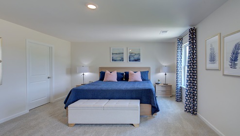 Primary bedroom with carpet, and two small windows
