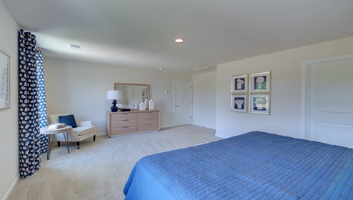 Primary bedroom with carpet, and two small windows
