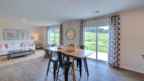 Breakfast area beside kitchen and living room with sliding glass back door