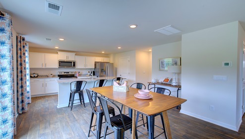 Breakfast area beside kitchen and living room with sliding glass back door