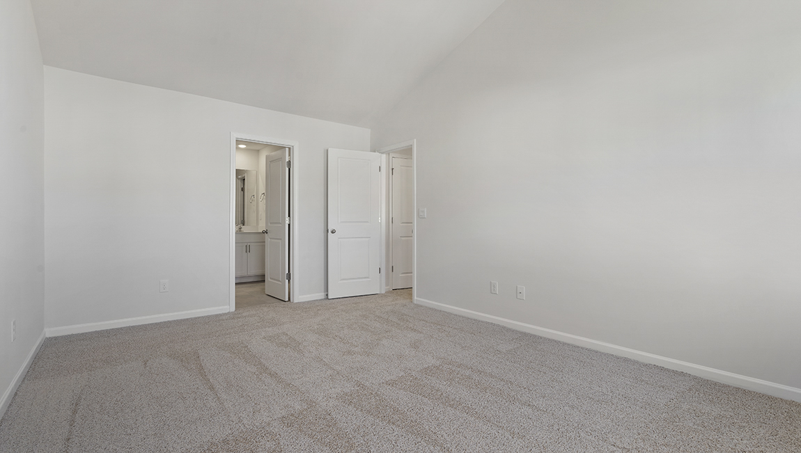 Primary bedroom, carpeted with two windows