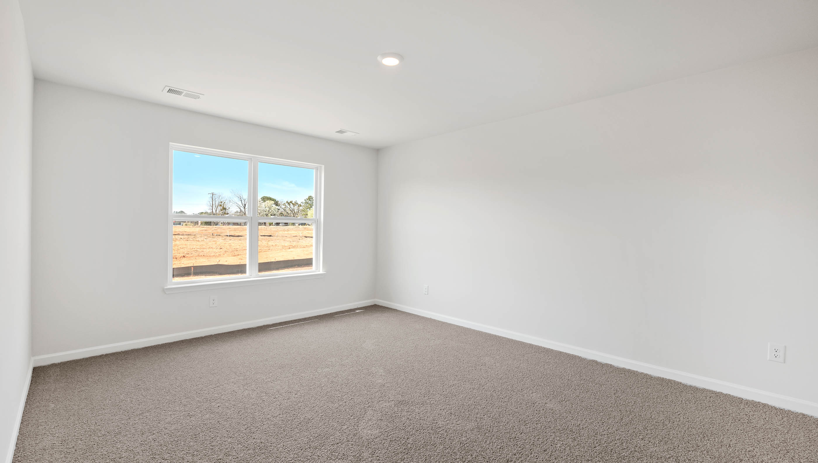 Carpeted bedroom with large window