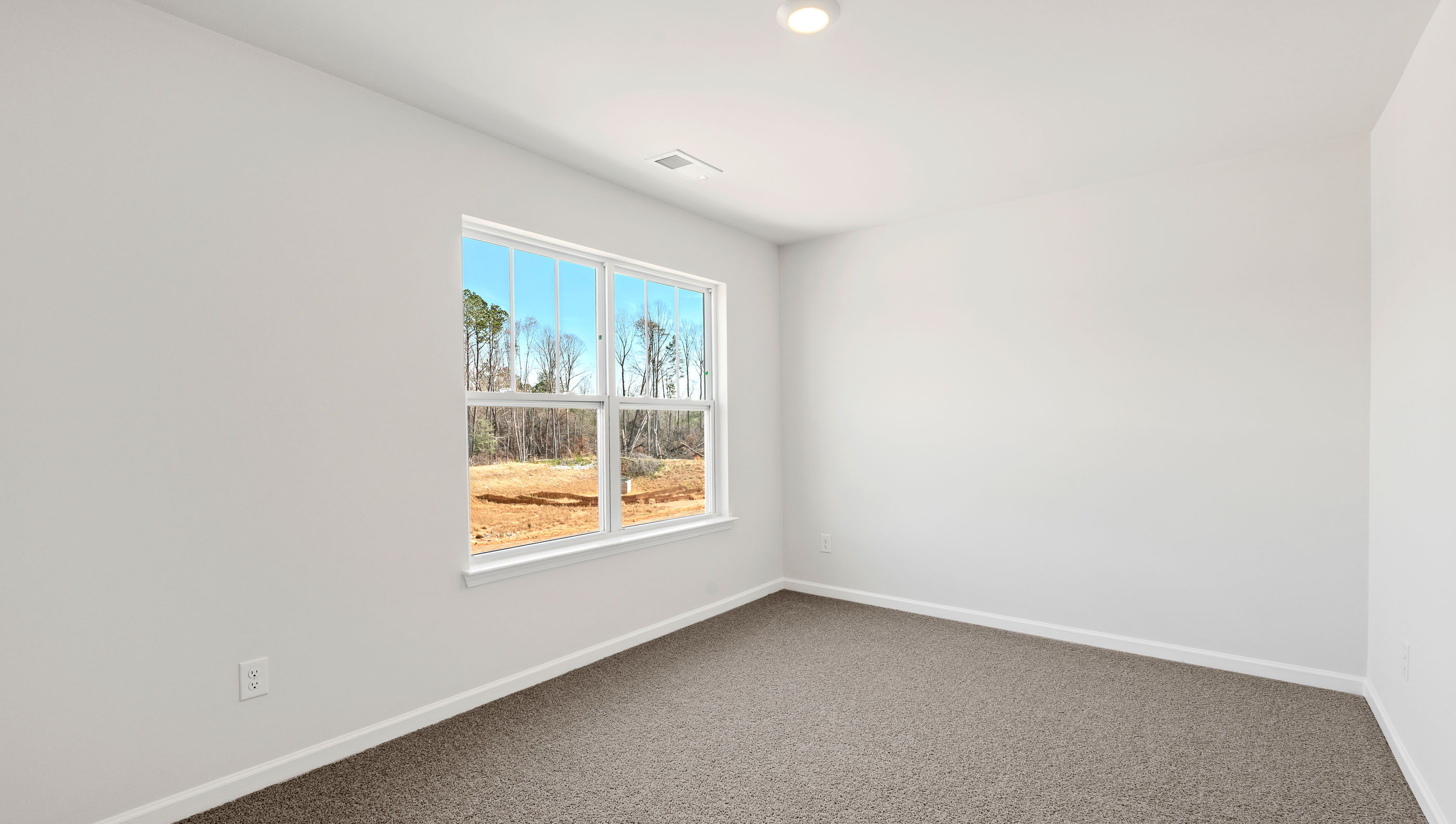 Carpeted bedroom with large window