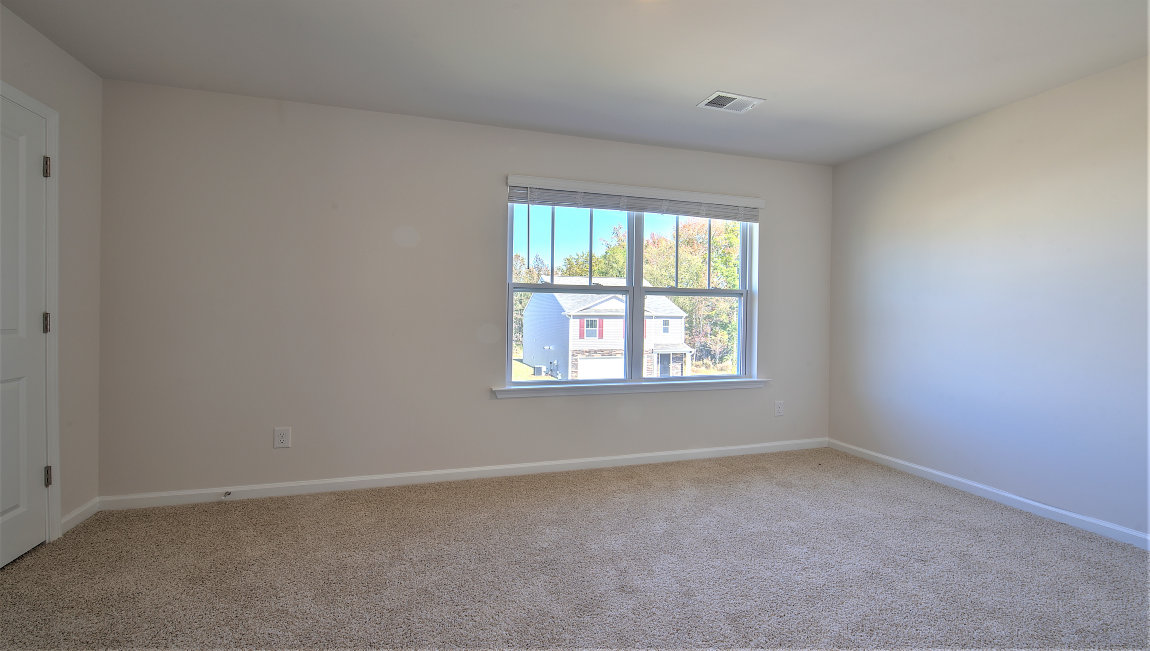 Carpeted bedroom with large window