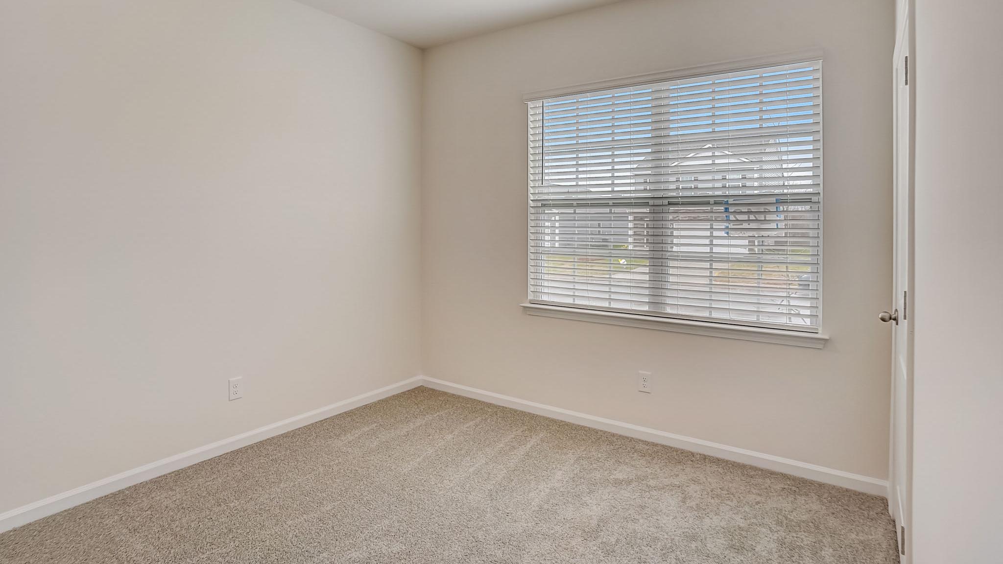 Carpeted bedroom with large window