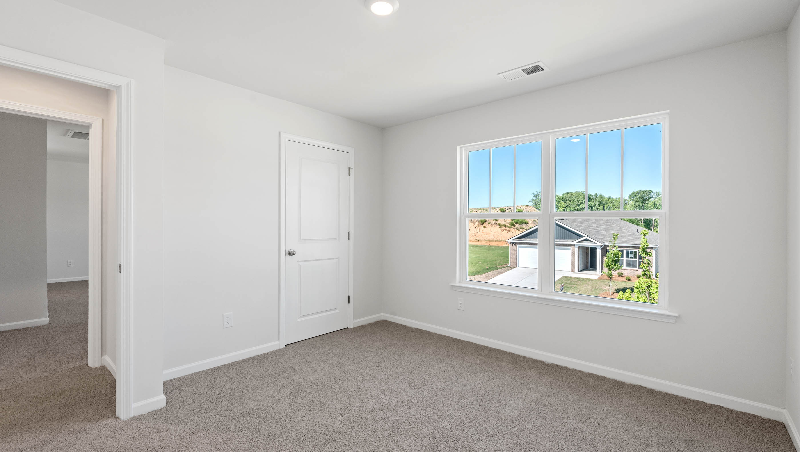 Carpeted bedroom with large windows