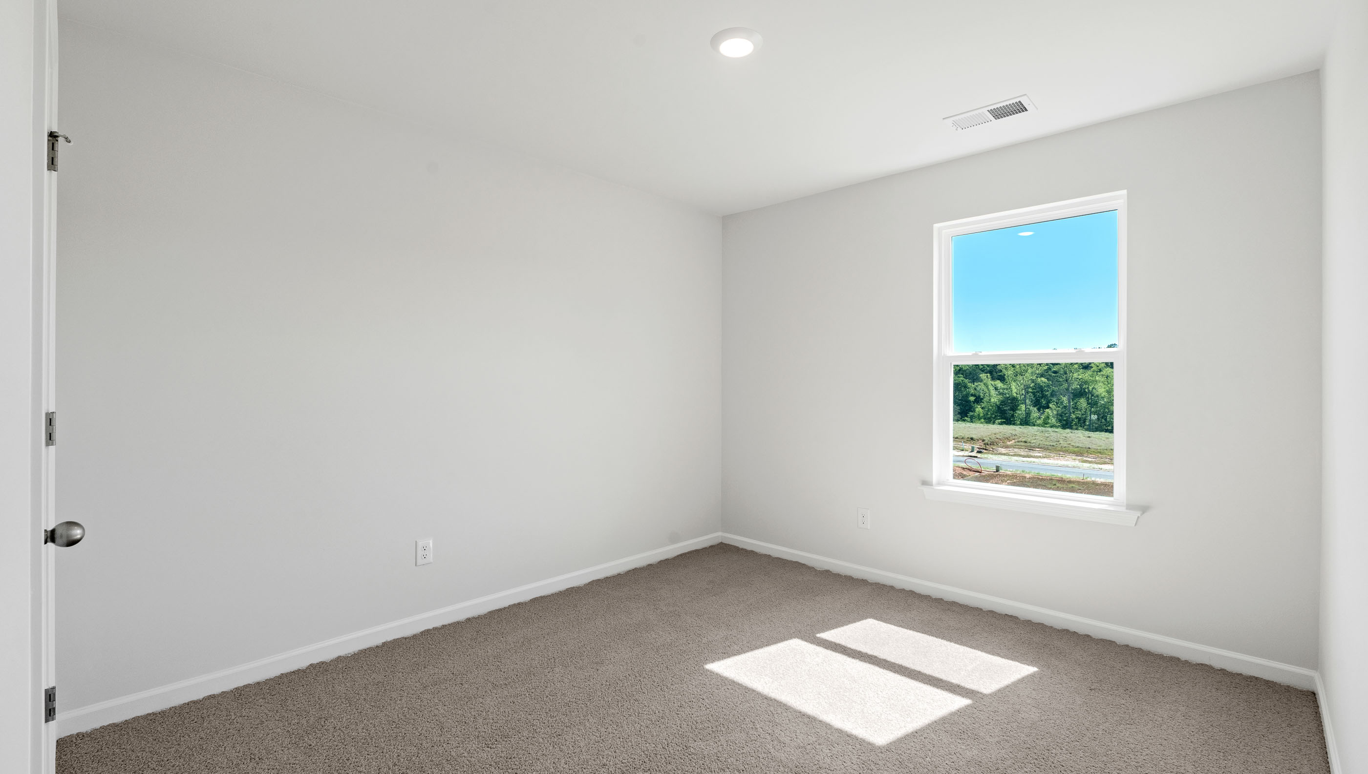 Carpeted bedroom with large window