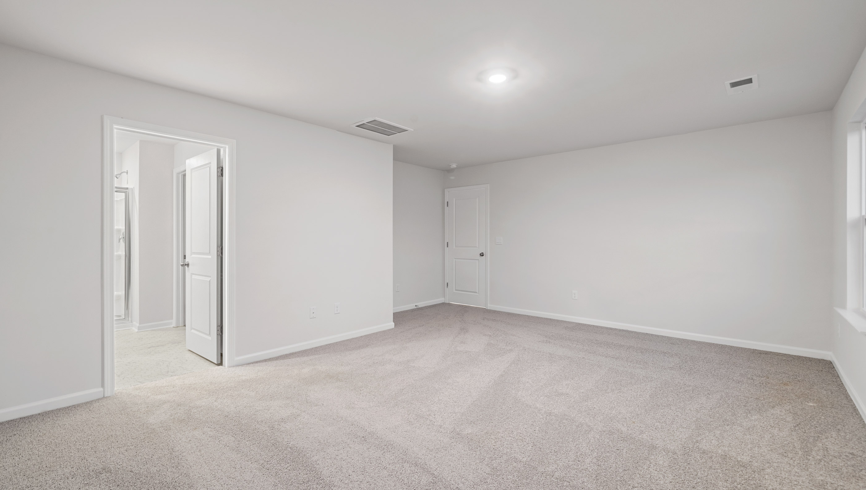 Carpeted bedroom with large windows