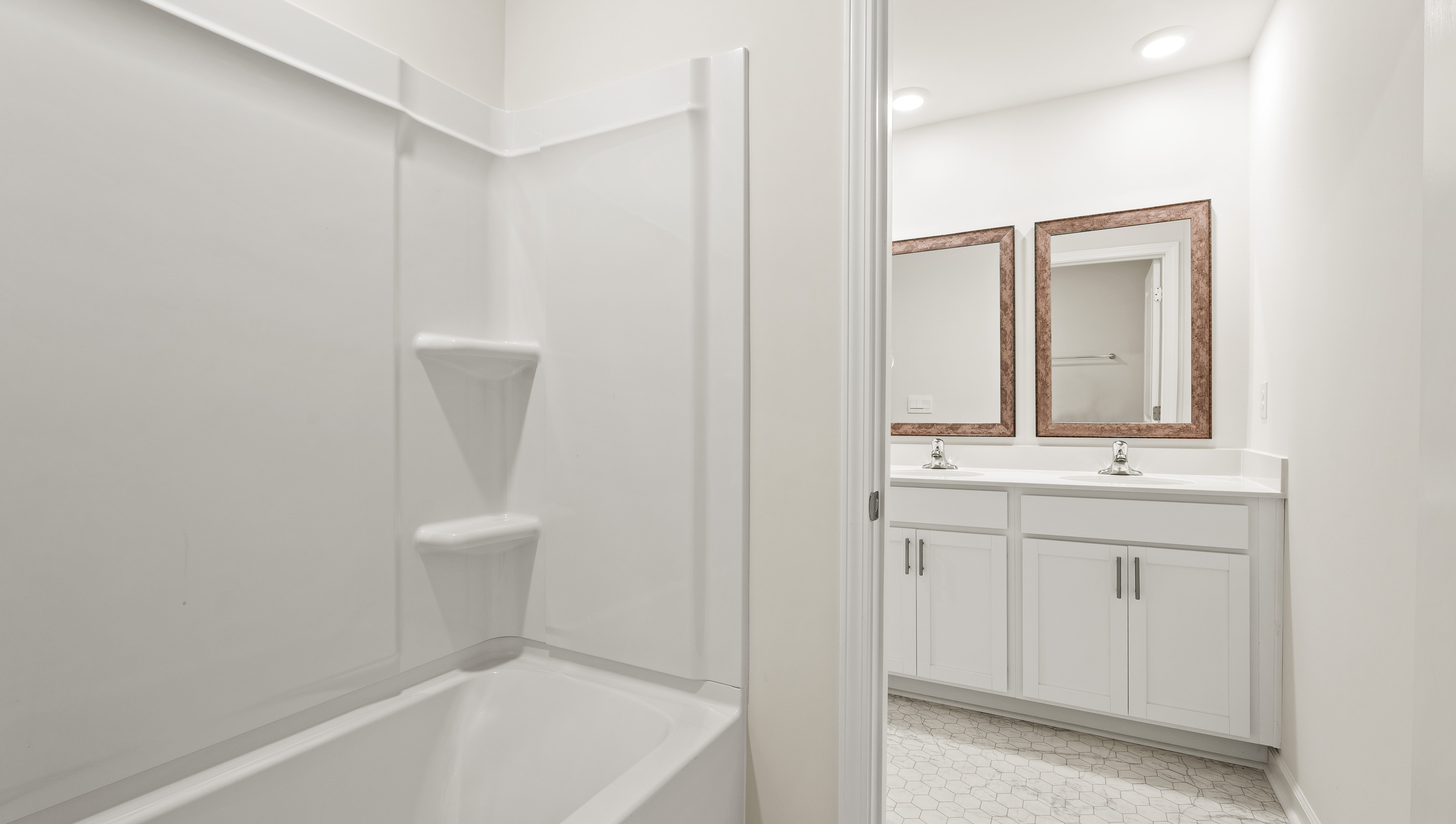 Bathroom with double vanity and bathtub