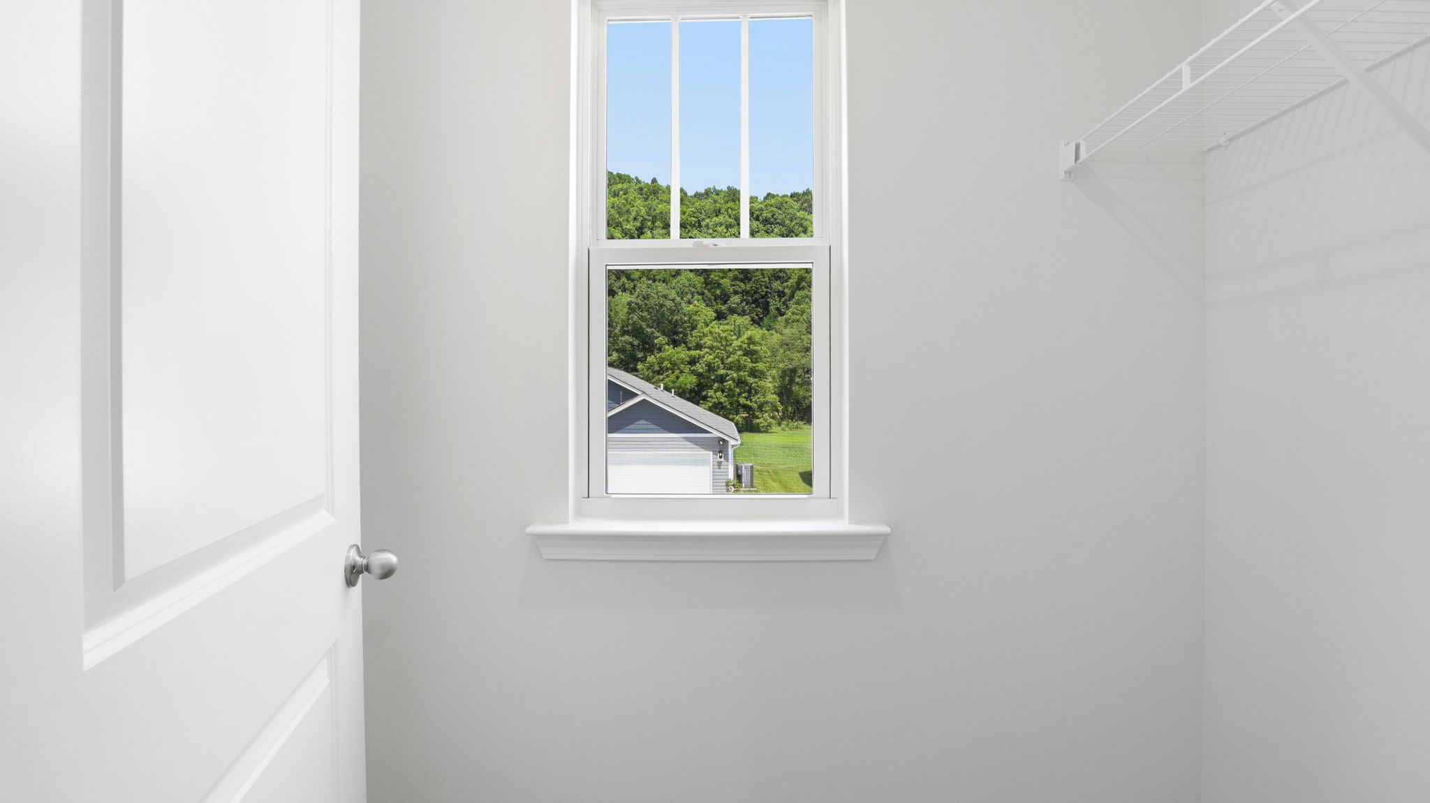 Primary bedroom walk in closet with window