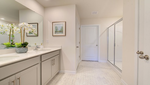 bathroom with double sink vanity and bathtub shower combination