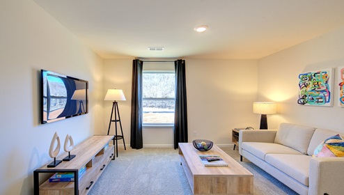 carpeted loft space with window