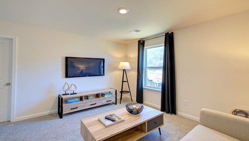 carpeted loft space with window