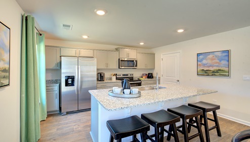 Kitchen and island with gray cabinets and stainless steel appliances
