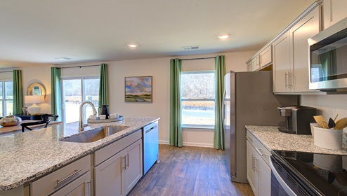 Kitchen and island with gray cabinets and stainless steel appliances