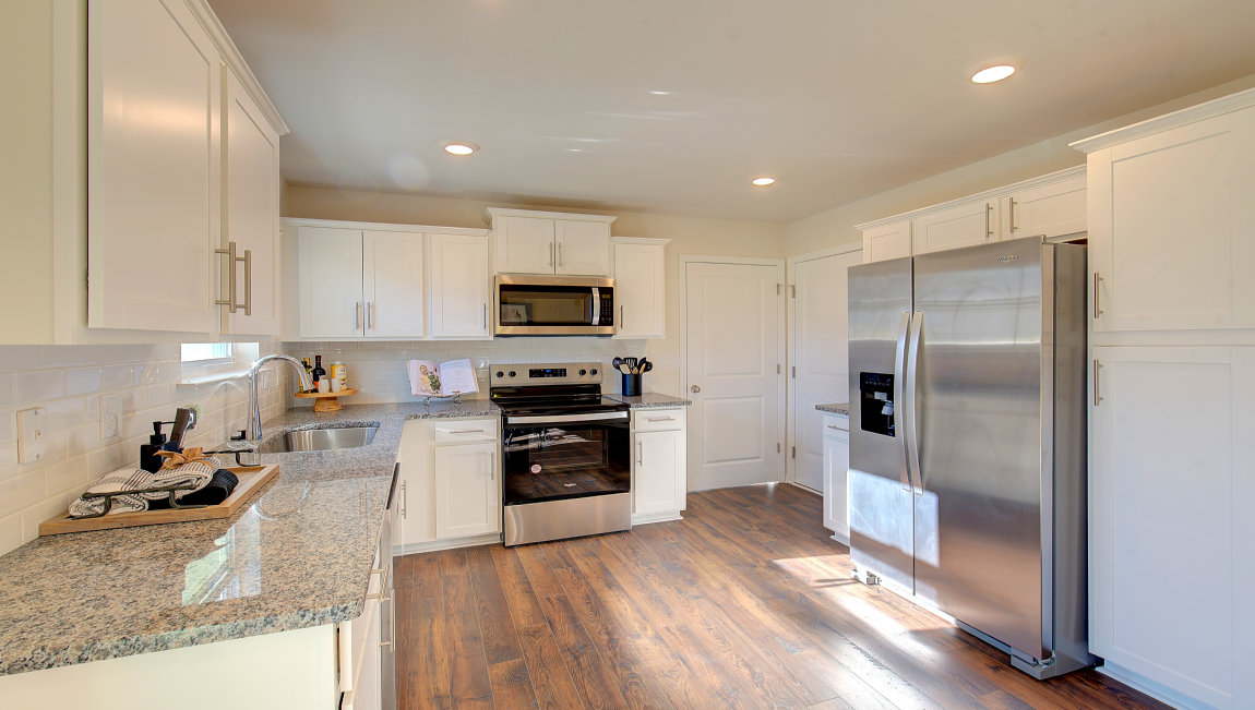 Kitchen with white cabinets, and wood floors