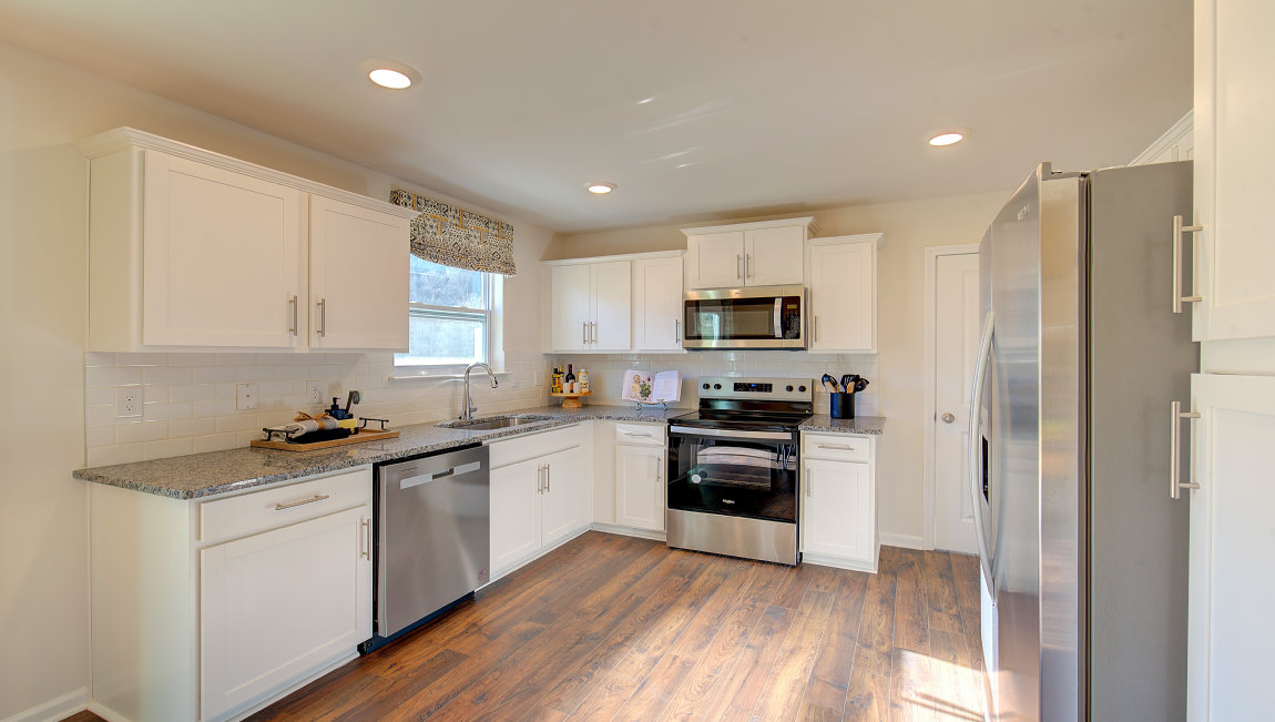 Kitchen with white cabinets, and wood floors