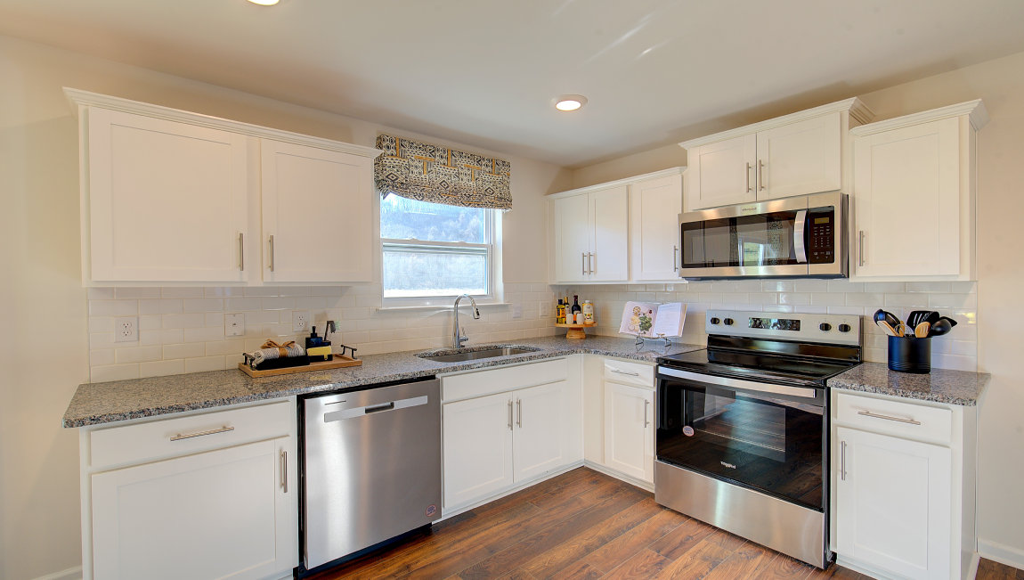Kitchen with white cabinets, and wood floors