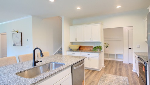 Kitchen and island with wood floors, white cabinets, and stainless steel appliances