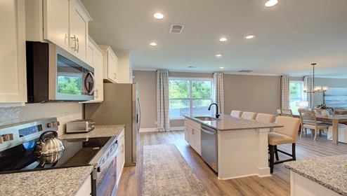 Kitchen and island with wood floors, white cabinets, and stainless steel appliances