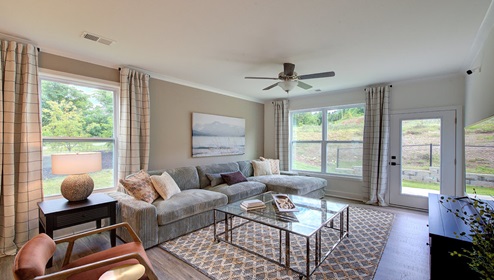 Living room with large window and back door, with wood floors