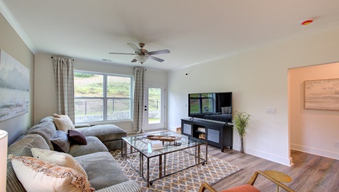 Living room with large window and back door, with wood floors