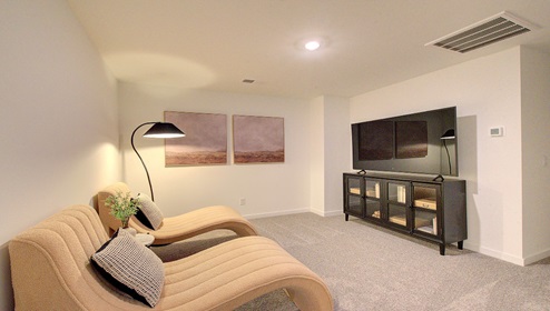 Upstairs loft space, carpeted, with staircase railing