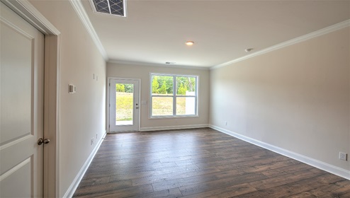 Living room with large window and back door, with wood floors