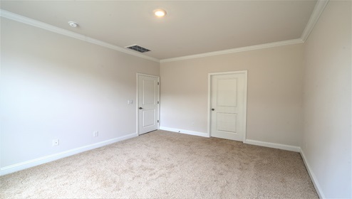 Carpeted bedroom, view of closet door and entry door