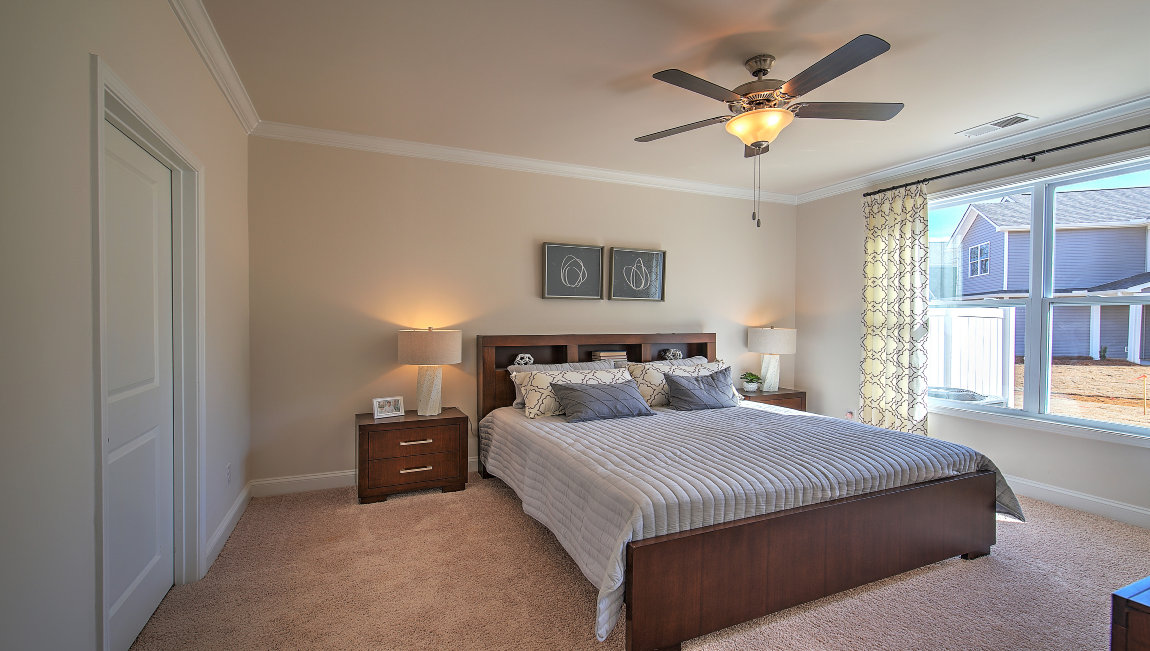 Carpeted primary bedroom with large windows