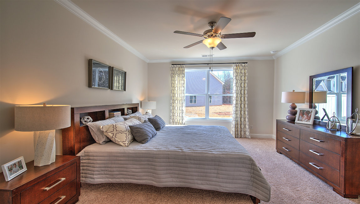 Carpeted primary bedroom with large windows