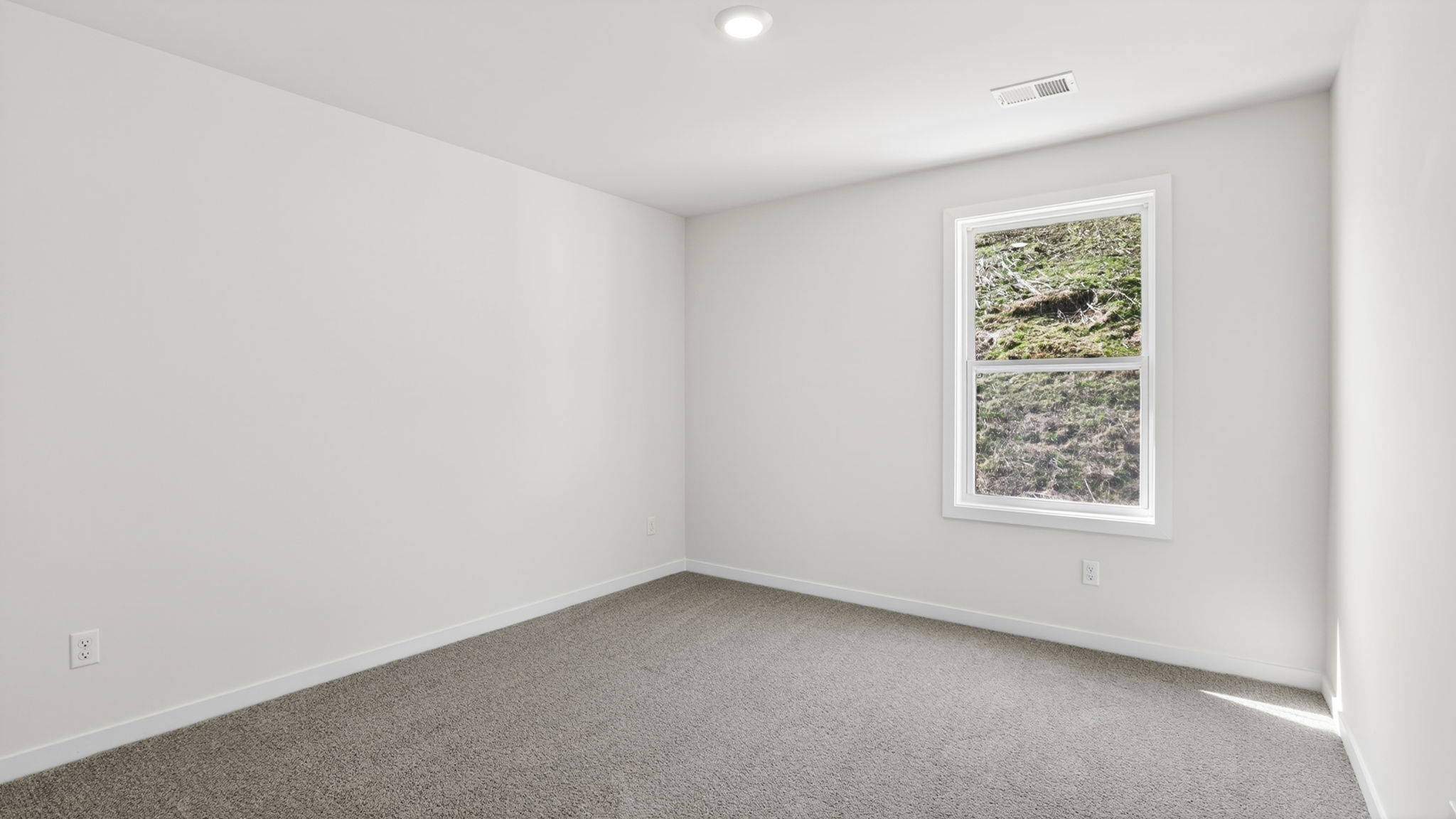 Carpeted front bedroom with large windows
