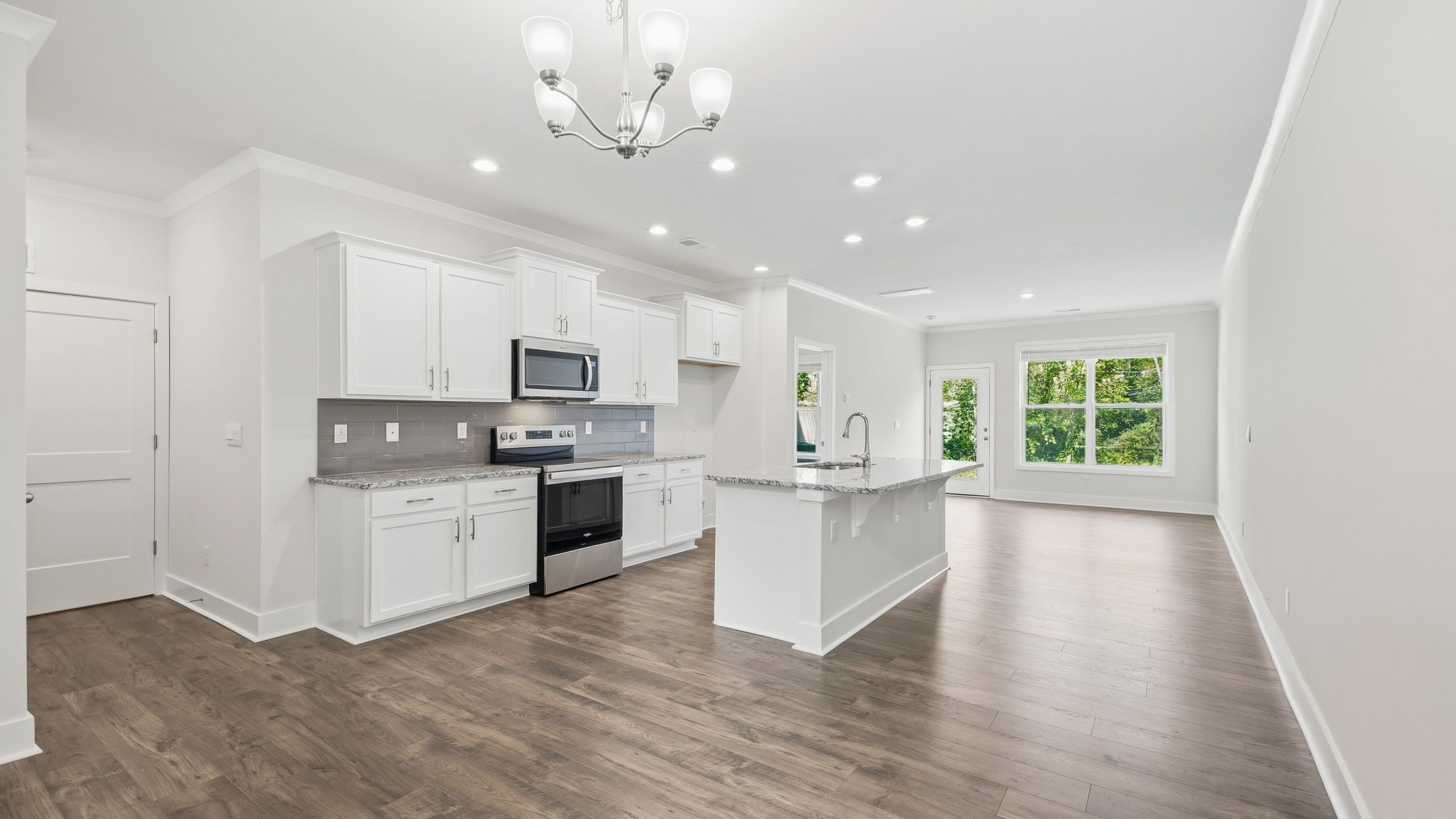 Open concept kitchen with stainless steel appliances and large island