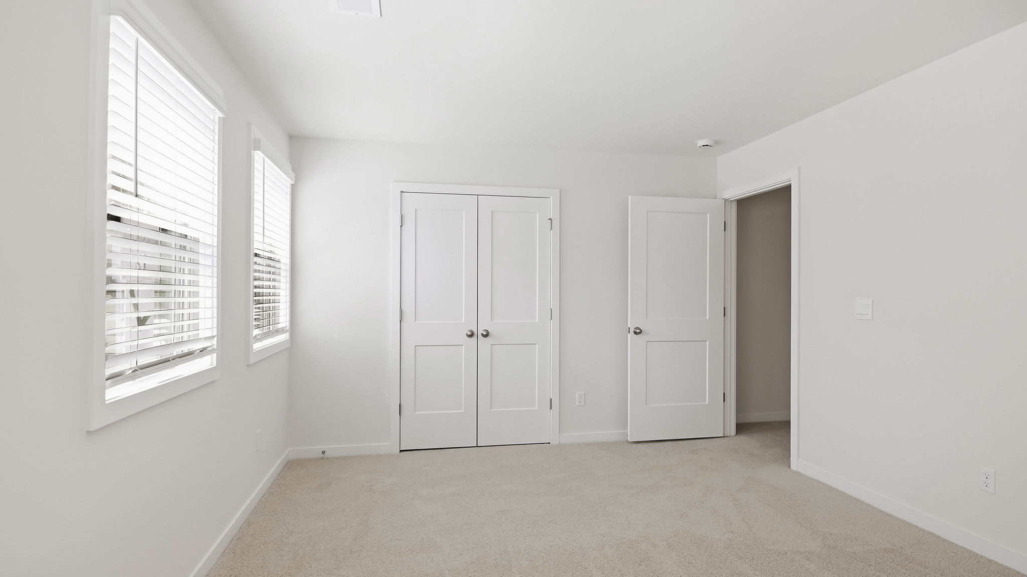 Carpeted bedroom with large windows