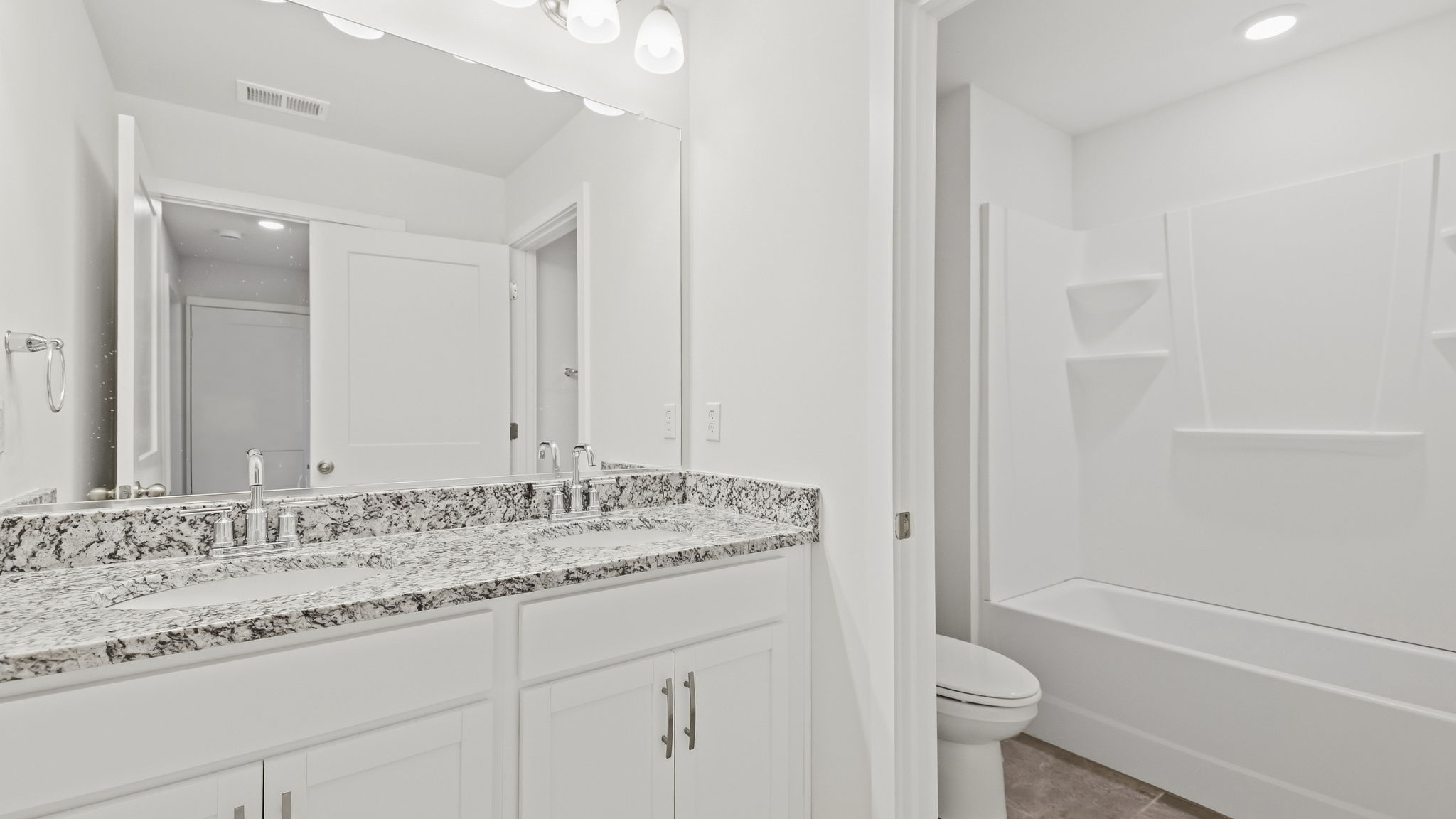 Primary bathroom with dual vanity and bathtub