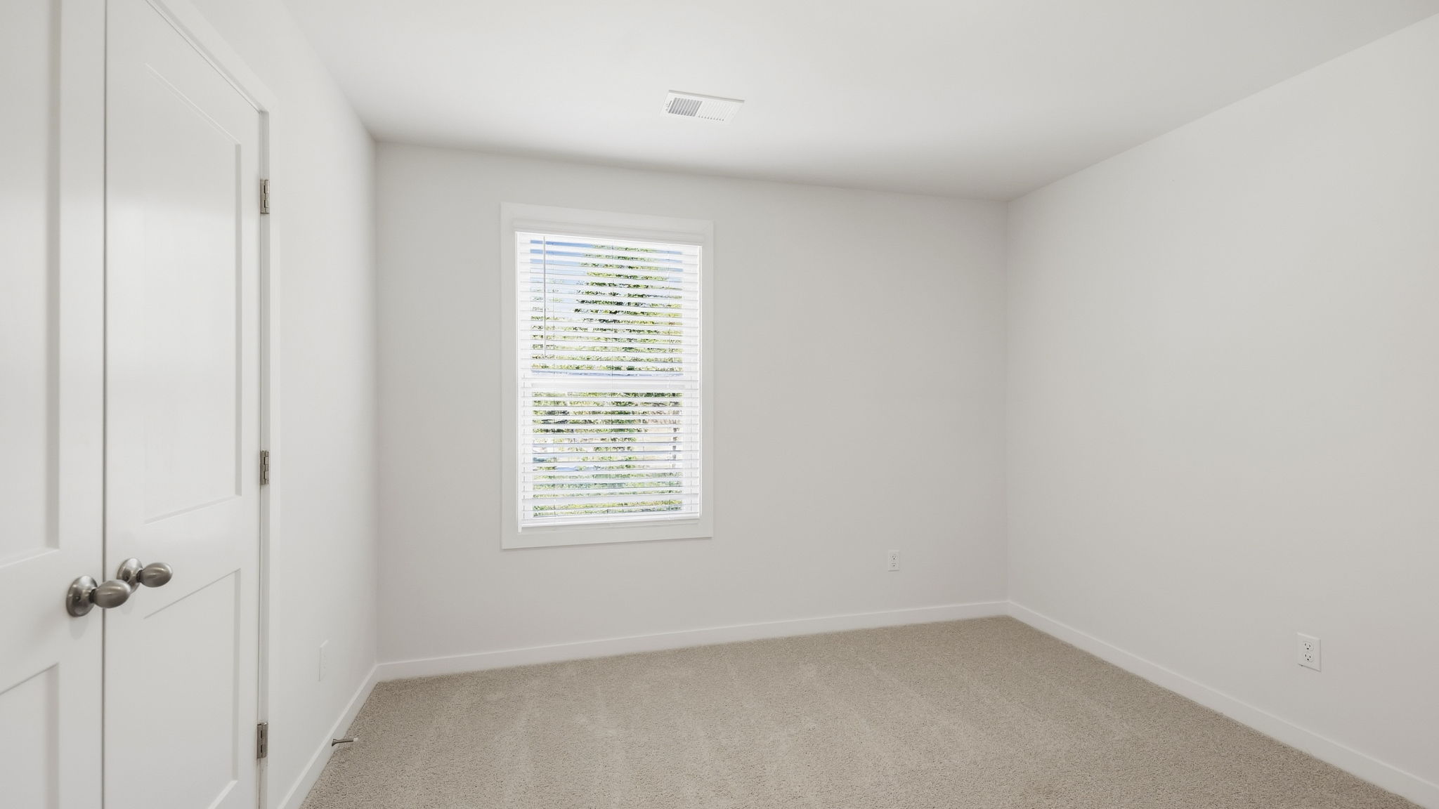 Carpeted bedroom with large windows