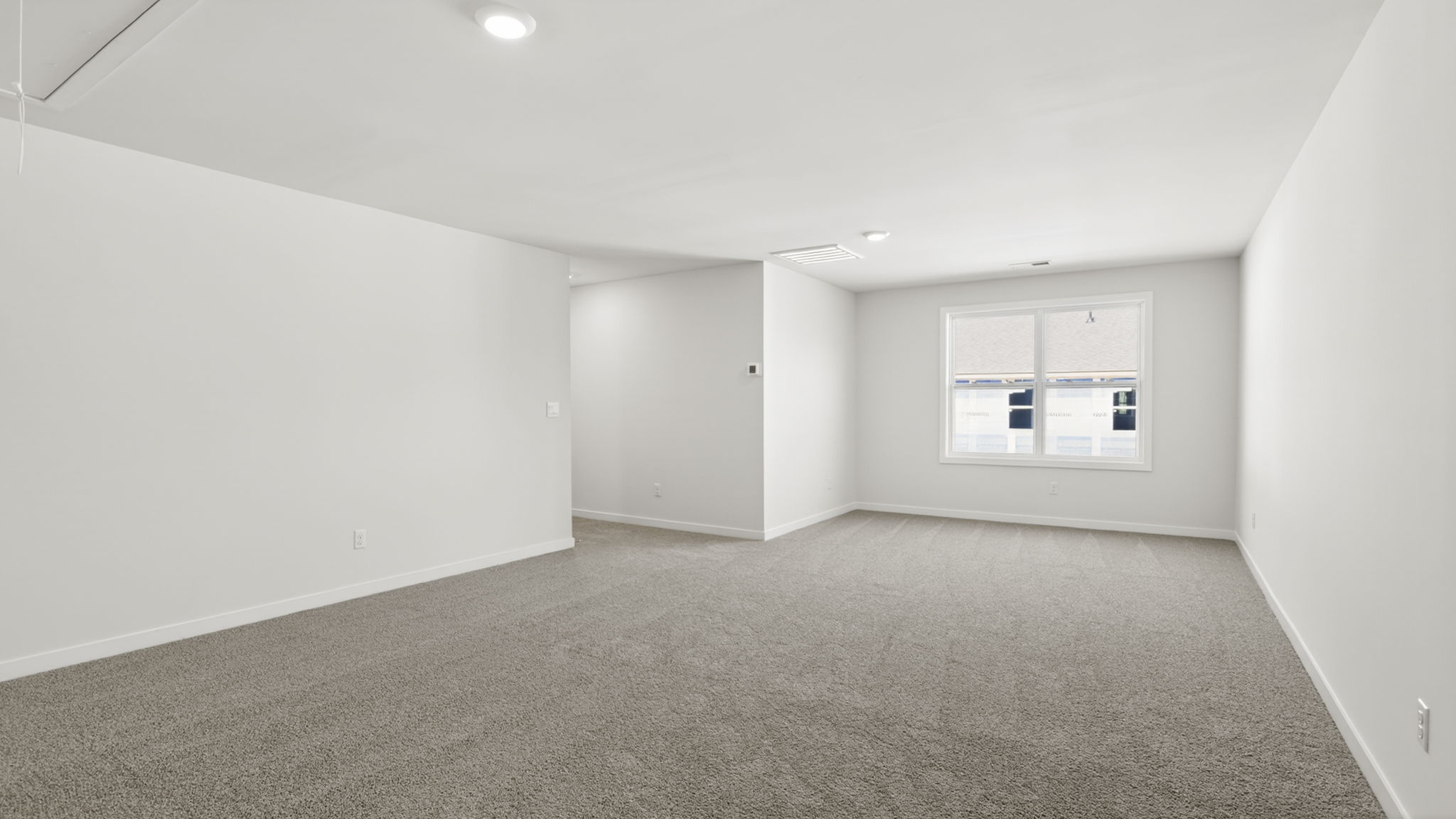 Carpeted loft area with large windows
