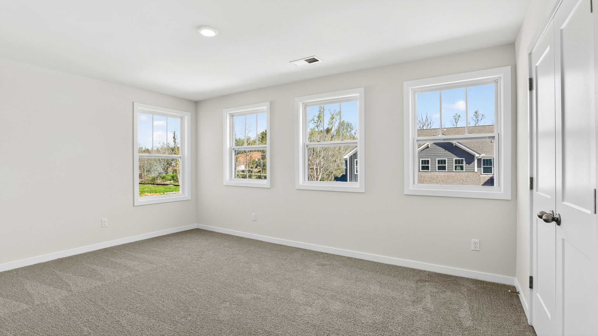 Carpeted bedroom with multiple windows