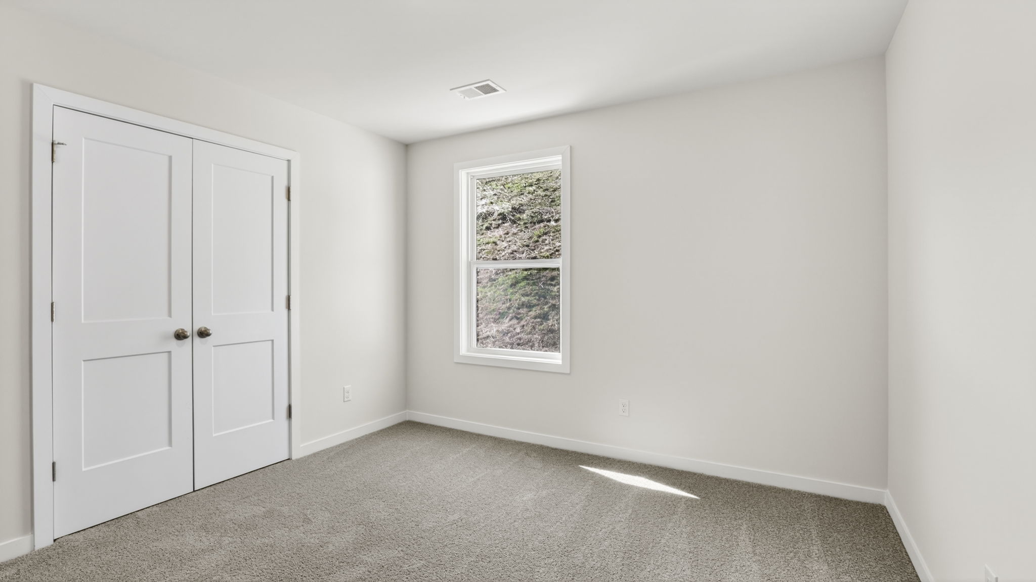 Carpeted bedroom with closet