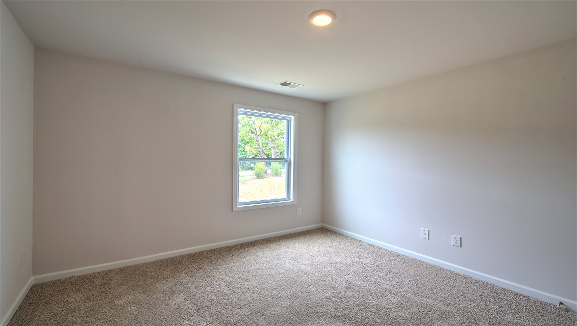 carpeted bedroom with large window