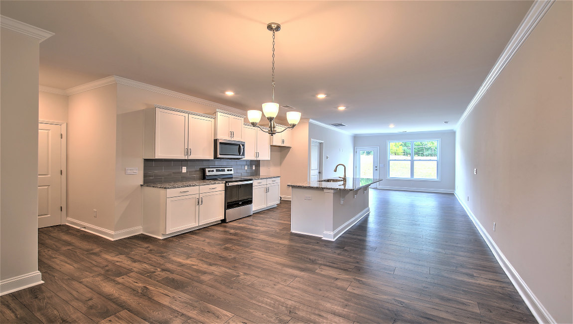 Kitchen and island with wood floors, white cabinets, and stainless steel appliances