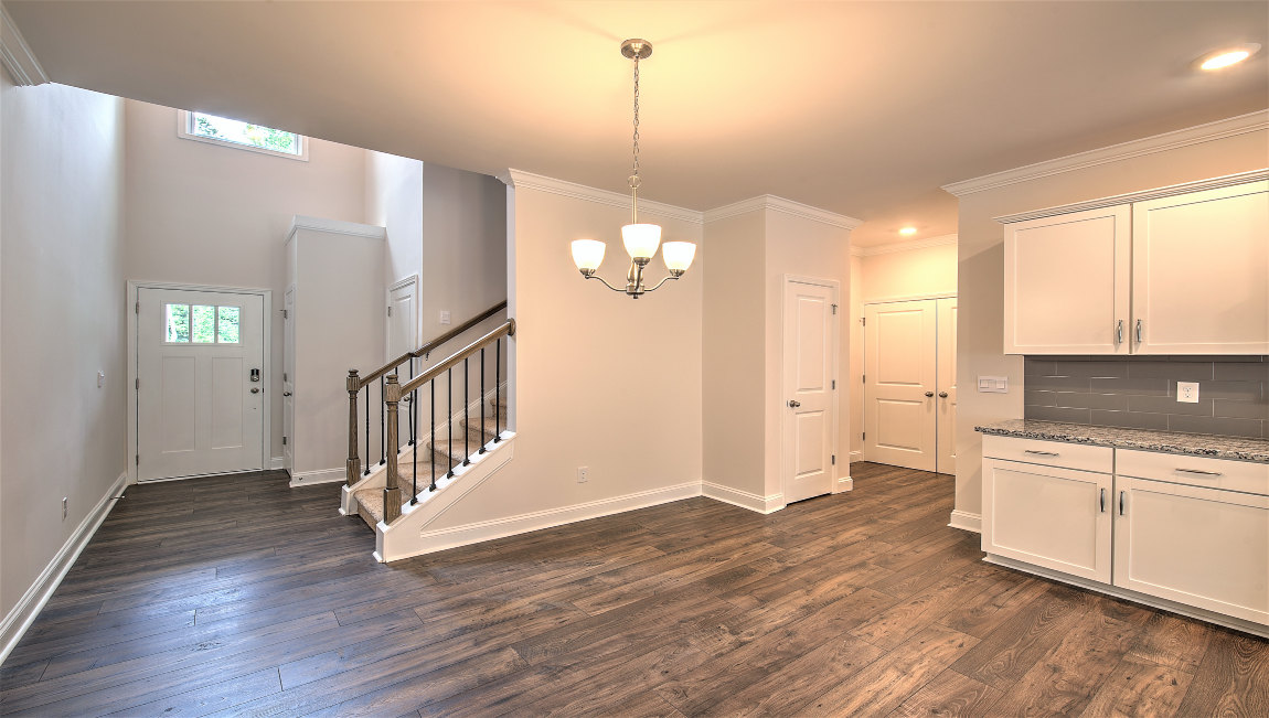 View of foyer, staircase, and edge of kitchen