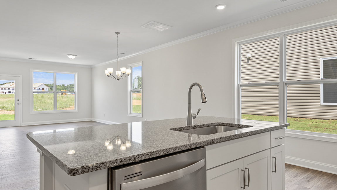 Kitchen and island with grey cabinets and stainless steel appliances
