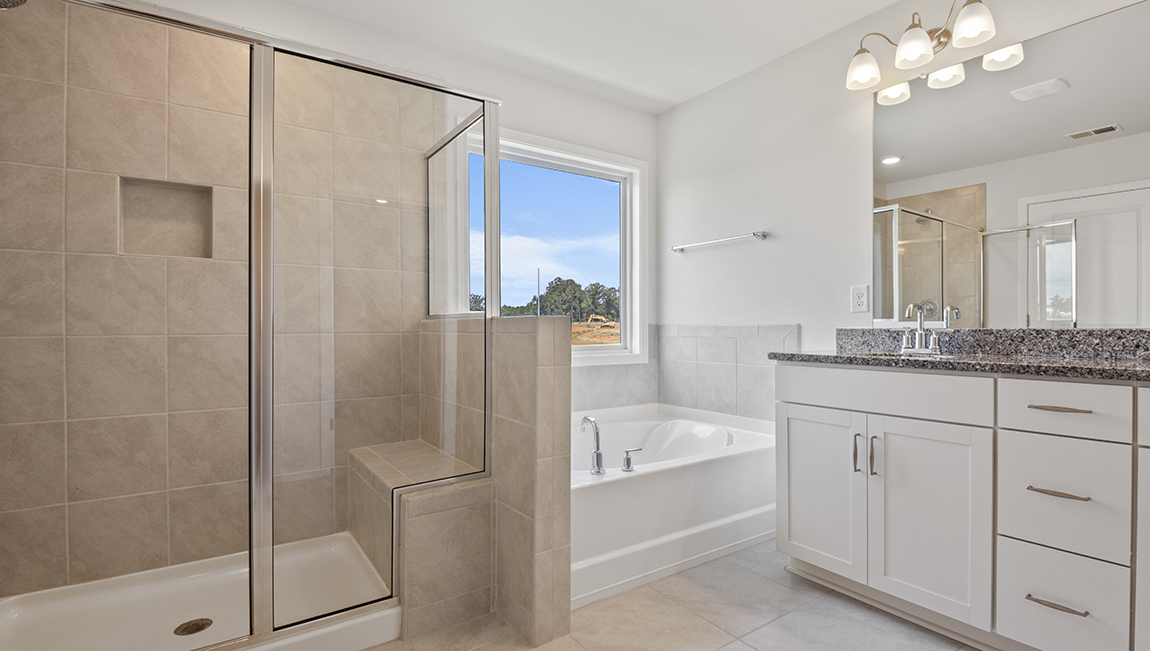 Primary bathroom with large bathtub and glass door shower