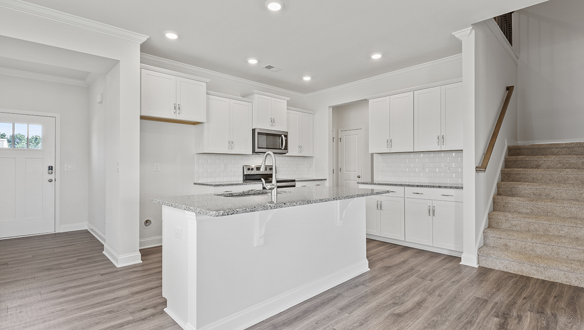 Kitchen and island with grey cabinets and stainless steel appliances