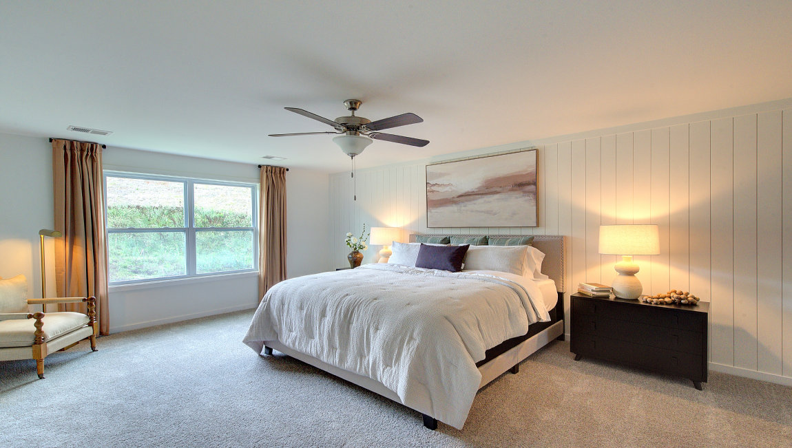 Carpeted primary bedroom with large windows