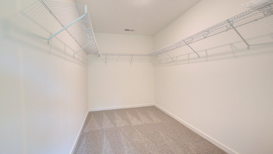 Primary walk in closet with shelving