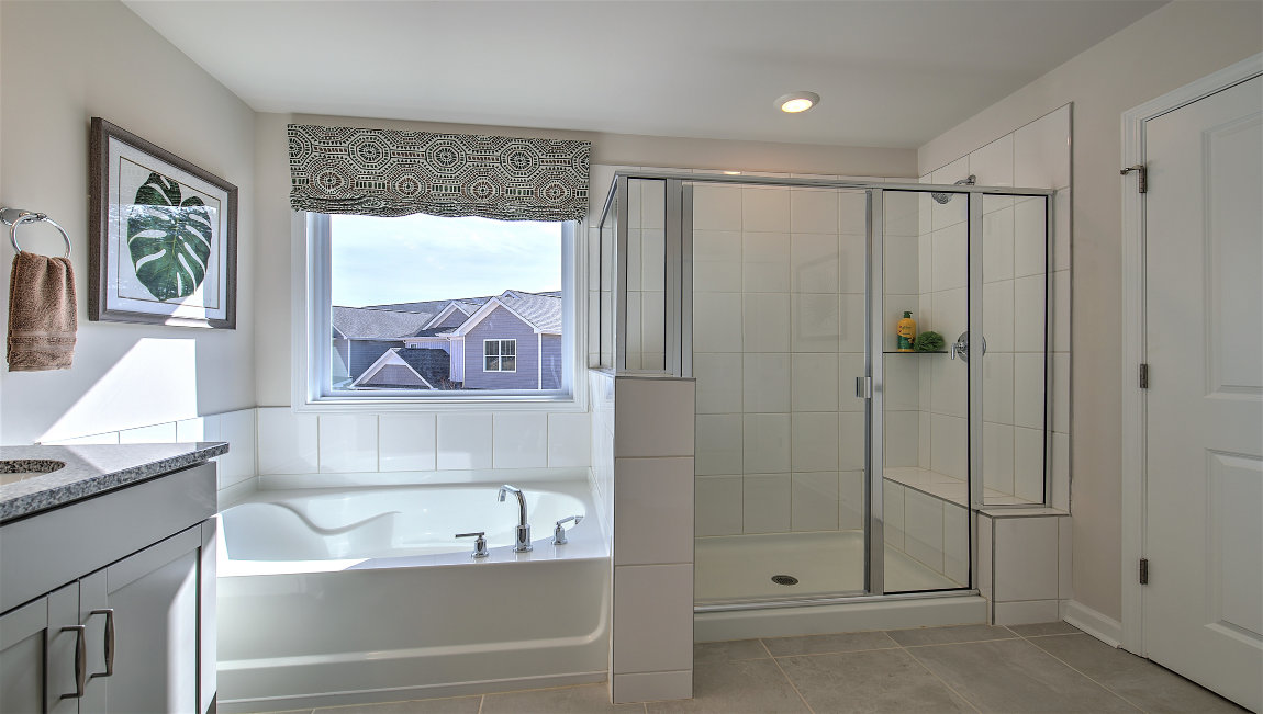 Primary bathroom with large bathtub and glass door shower