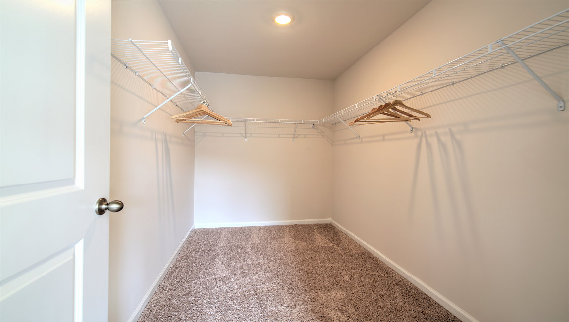 Primary bedroom walk in closet