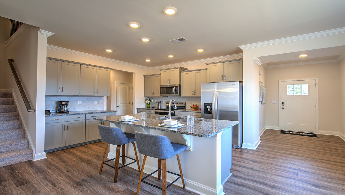 Kitchen and island with grey cabinets and stainless steel appliances